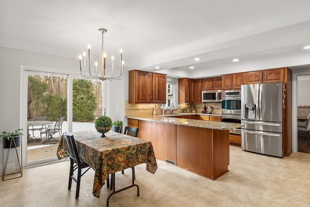 kitchen with a peninsula, light stone countertops, appliances with stainless steel finishes, and a wealth of natural light