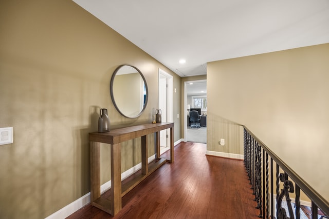 hall featuring baseboards, wood finished floors, and recessed lighting