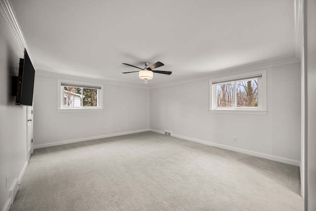 unfurnished room featuring light carpet, ceiling fan, baseboards, and crown molding