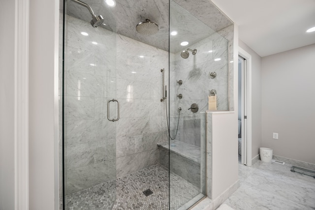 full bathroom with a stall shower, marble finish floor, and baseboards