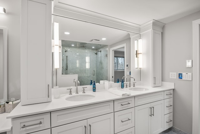 full bathroom with double vanity, a stall shower, a sink, and recessed lighting