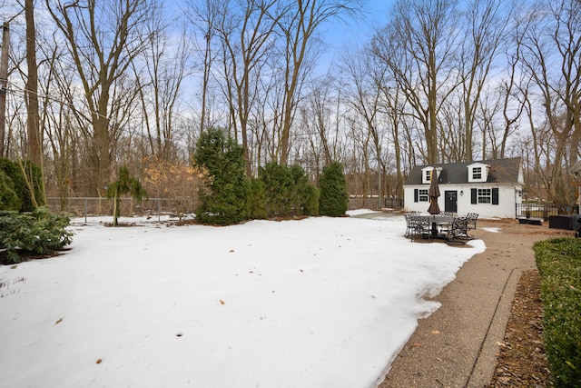 snowy yard with fence and outdoor dining area