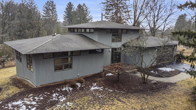 exterior space featuring roof with shingles