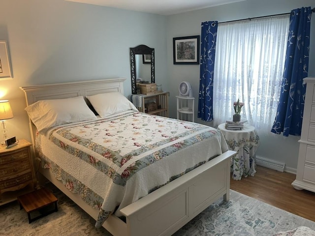 bedroom with light wood-type flooring and baseboard heating