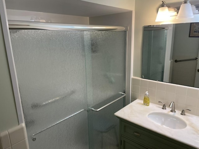 full bath featuring a shower stall, tile walls, backsplash, and vanity