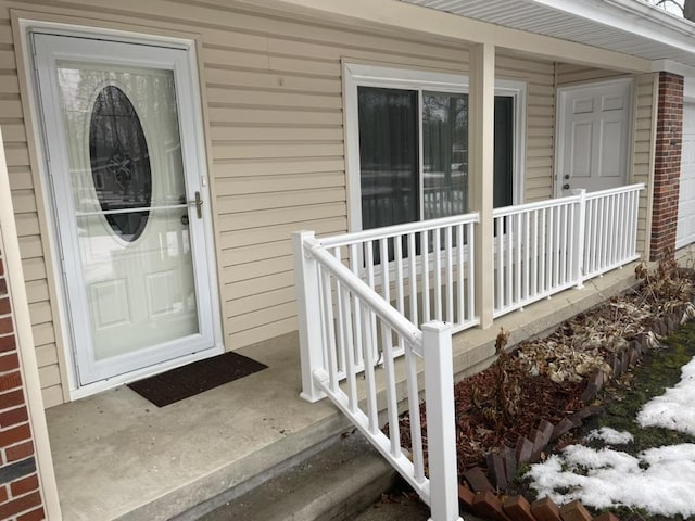 doorway to property featuring covered porch and brick siding