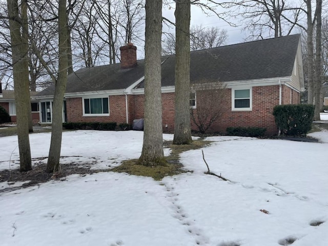 view of front of house featuring brick siding and a chimney