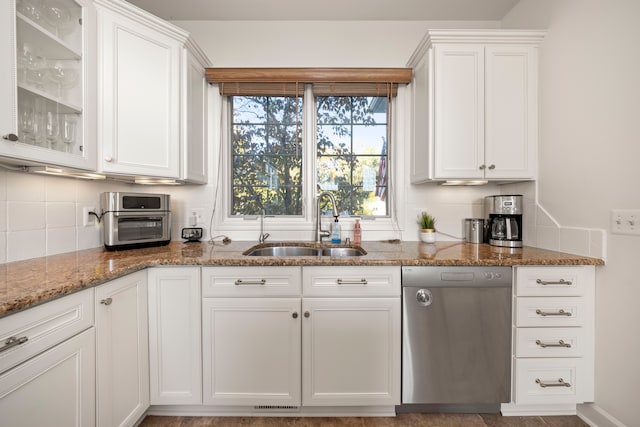 kitchen featuring decorative backsplash, white cabinetry, dishwasher, and a sink