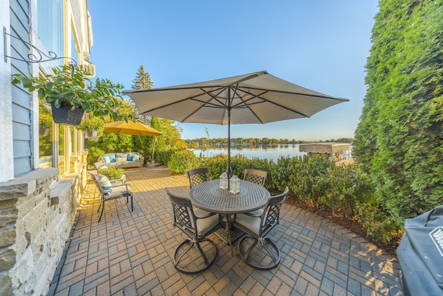 view of patio featuring area for grilling, outdoor lounge area, and a water view