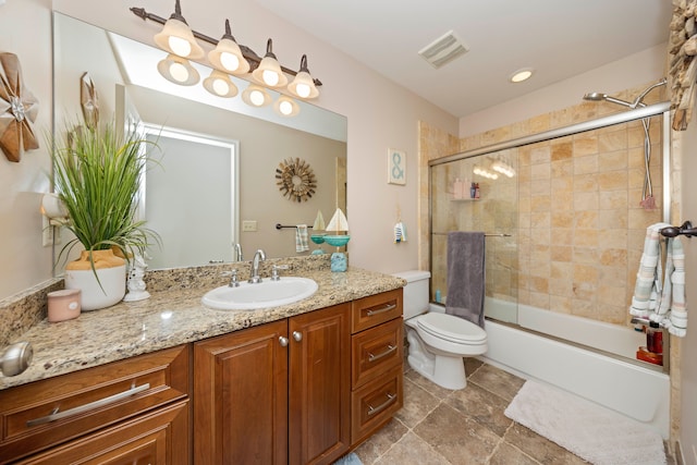 bathroom with toilet, enclosed tub / shower combo, visible vents, and vanity