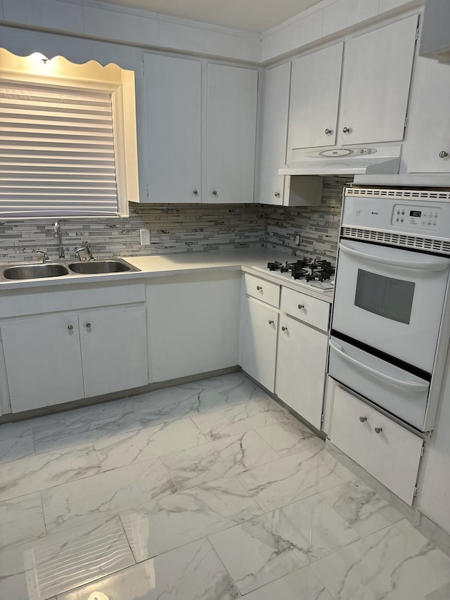 kitchen with a warming drawer, marble finish floor, white appliances, and under cabinet range hood