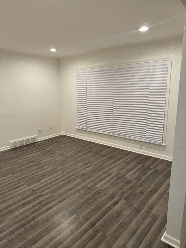 spare room with baseboards, visible vents, dark wood-type flooring, and recessed lighting