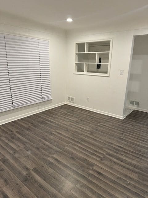 spare room with recessed lighting, visible vents, dark wood finished floors, and baseboards