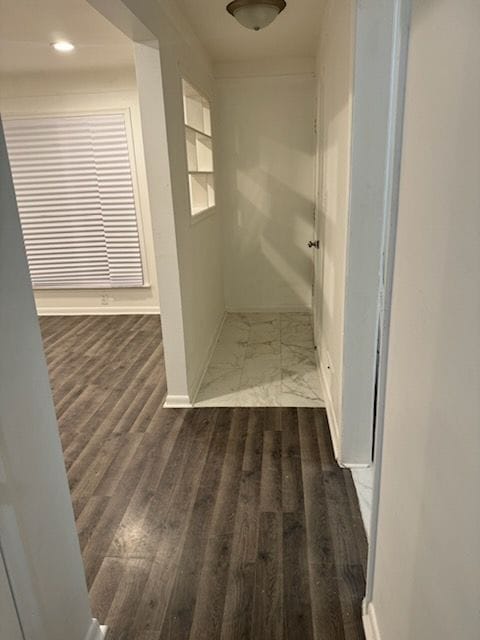 hallway with wood finished floors and baseboards