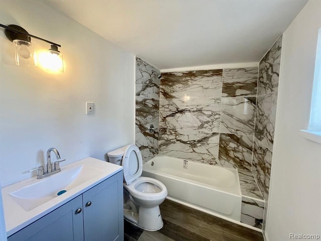 bathroom with toilet, shower / washtub combination, wood finished floors, and vanity