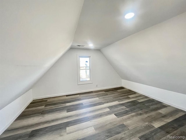 bonus room with visible vents, vaulted ceiling, baseboards, and wood finished floors