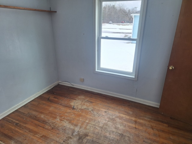 unfurnished room with wood-type flooring and baseboards