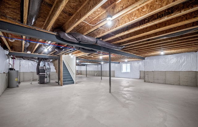 below grade area featuring water heater, heating unit, and stairs