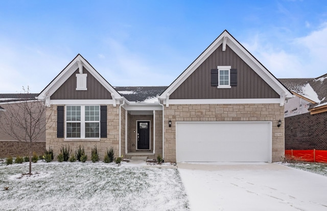 view of front of house with a garage, driveway, board and batten siding, and stone siding