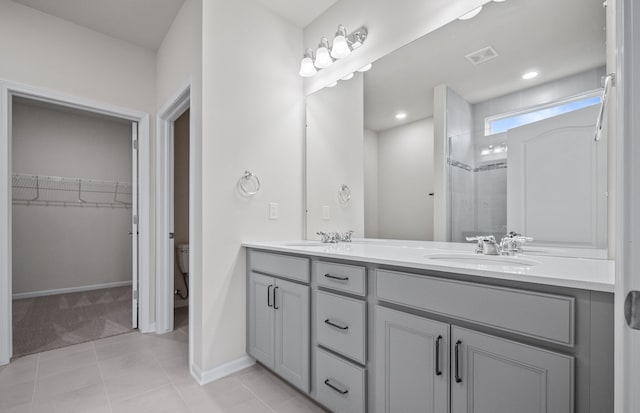 bathroom with double vanity, visible vents, a stall shower, a sink, and tile patterned floors