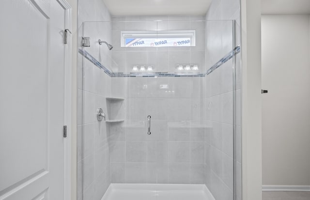 full bathroom featuring a shower stall and baseboards