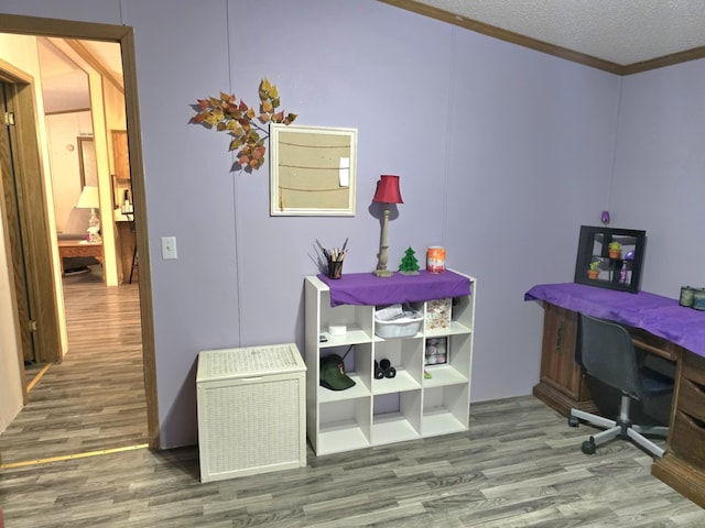 home office with ornamental molding, a textured ceiling, and wood finished floors