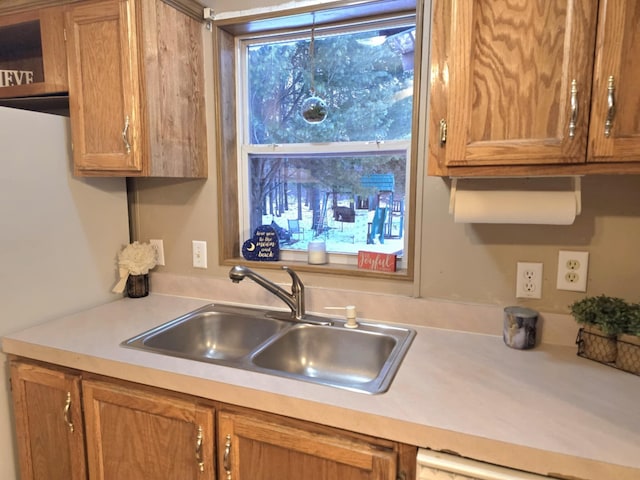 kitchen with brown cabinets, light countertops, and a sink