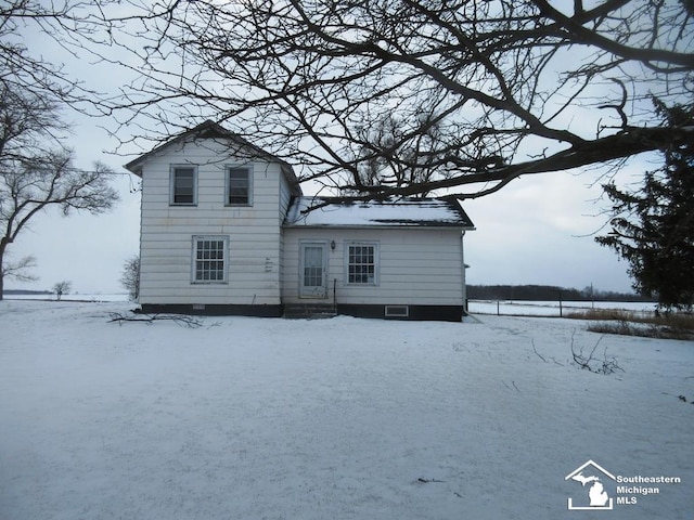 view of snow covered rear of property