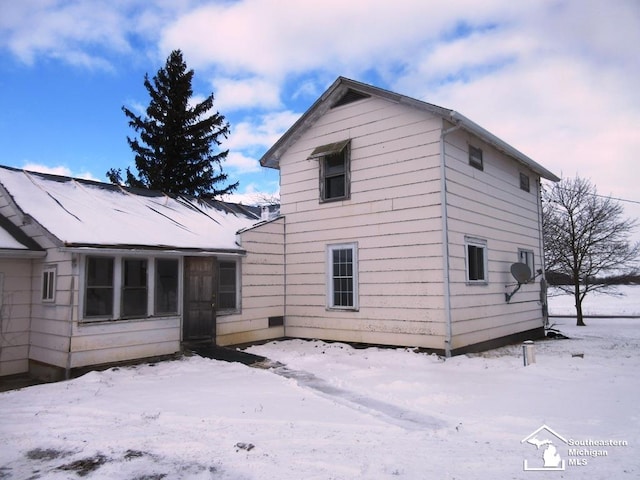 view of snow covered rear of property