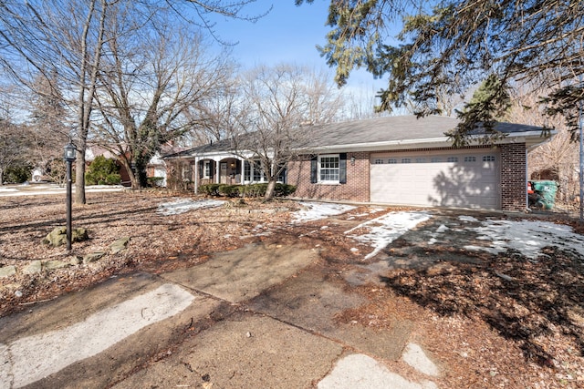 ranch-style house featuring a garage, brick siding, and driveway