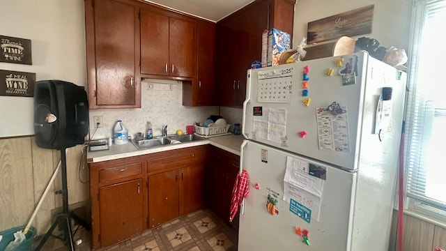 kitchen featuring light floors, light countertops, a sink, and freestanding refrigerator