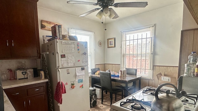 office with a wainscoted wall, ceiling fan, and wooden walls