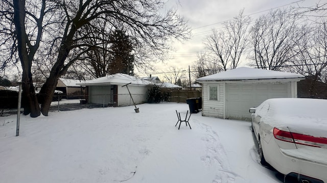 exterior space with a detached garage, fence, and an outbuilding