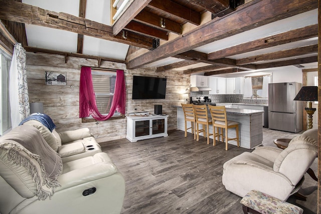 living room with beam ceiling, wooden walls, and wood finished floors