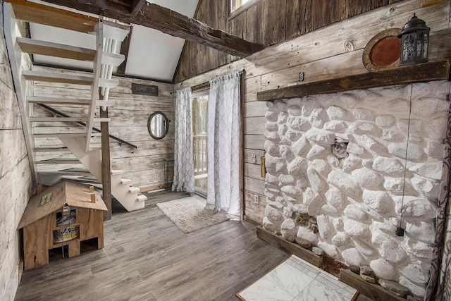 interior space featuring stairway, lofted ceiling, wooden walls, and wood finished floors