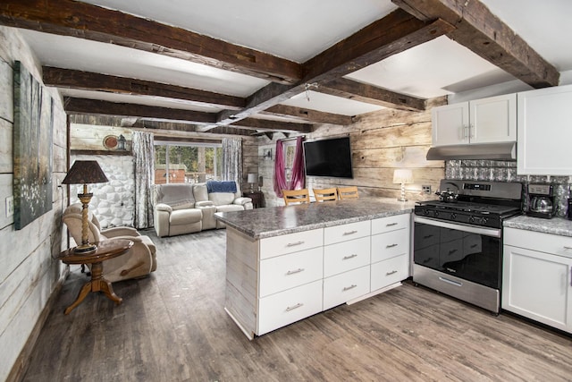 kitchen featuring a peninsula, under cabinet range hood, wood finished floors, and gas stove