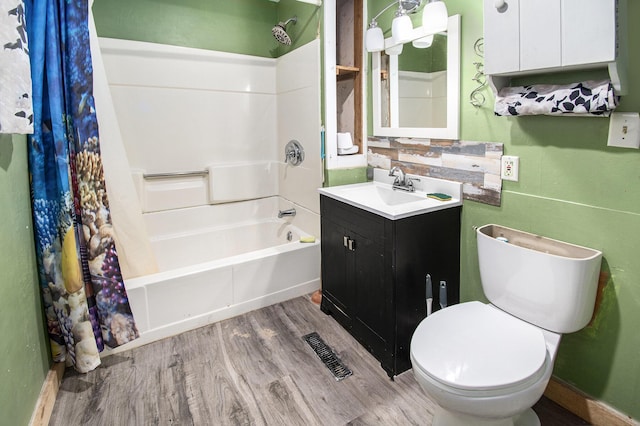 bathroom featuring visible vents, toilet, vanity, shower / tub combination, and wood finished floors