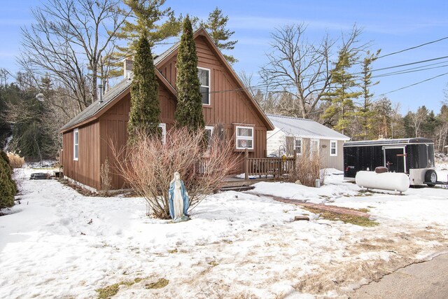 view of snowy exterior featuring a chimney