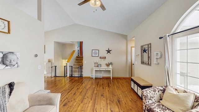 interior space featuring visible vents, ceiling fan, stairs, vaulted ceiling, and light wood-type flooring