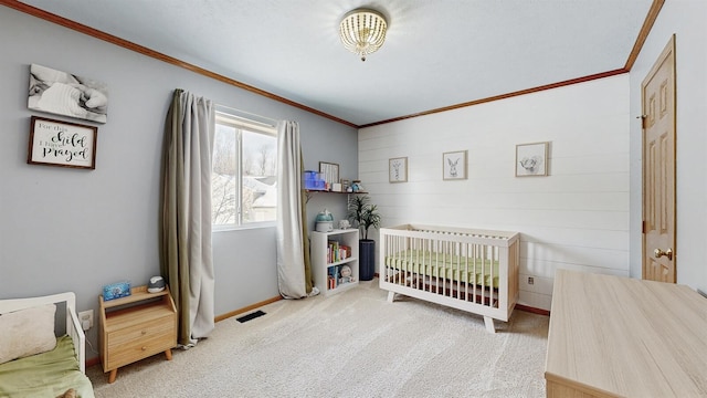 carpeted bedroom featuring a nursery area, ornamental molding, visible vents, and baseboards