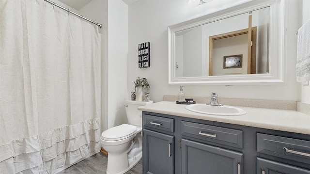 full bathroom with toilet, wood finished floors, and vanity