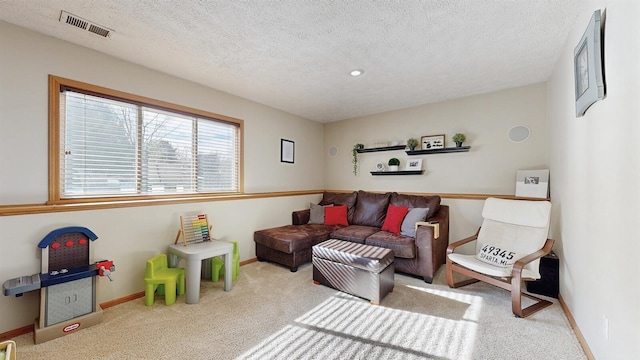 living room featuring a textured ceiling, carpet floors, visible vents, and baseboards