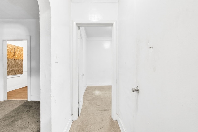 corridor featuring light carpet and arched walkways