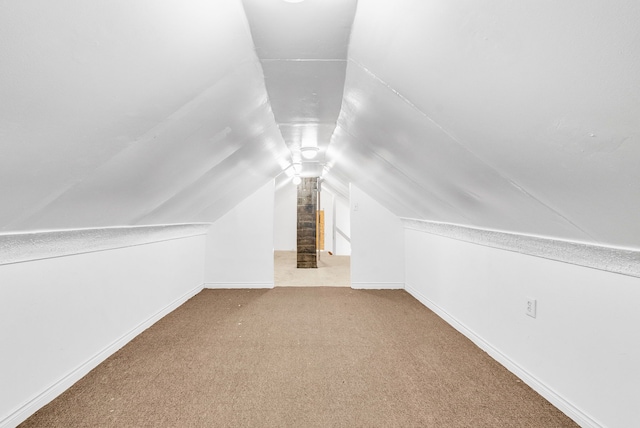 bonus room featuring lofted ceiling, carpet flooring, and baseboards