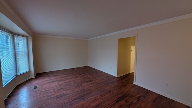 empty room with baseboards, ornamental molding, and dark wood-style flooring