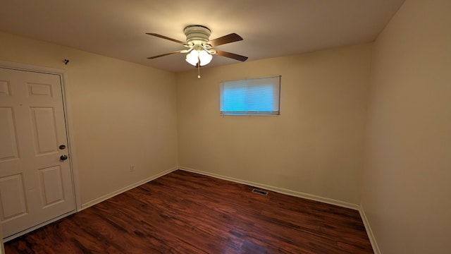 spare room with a ceiling fan, visible vents, baseboards, and wood finished floors