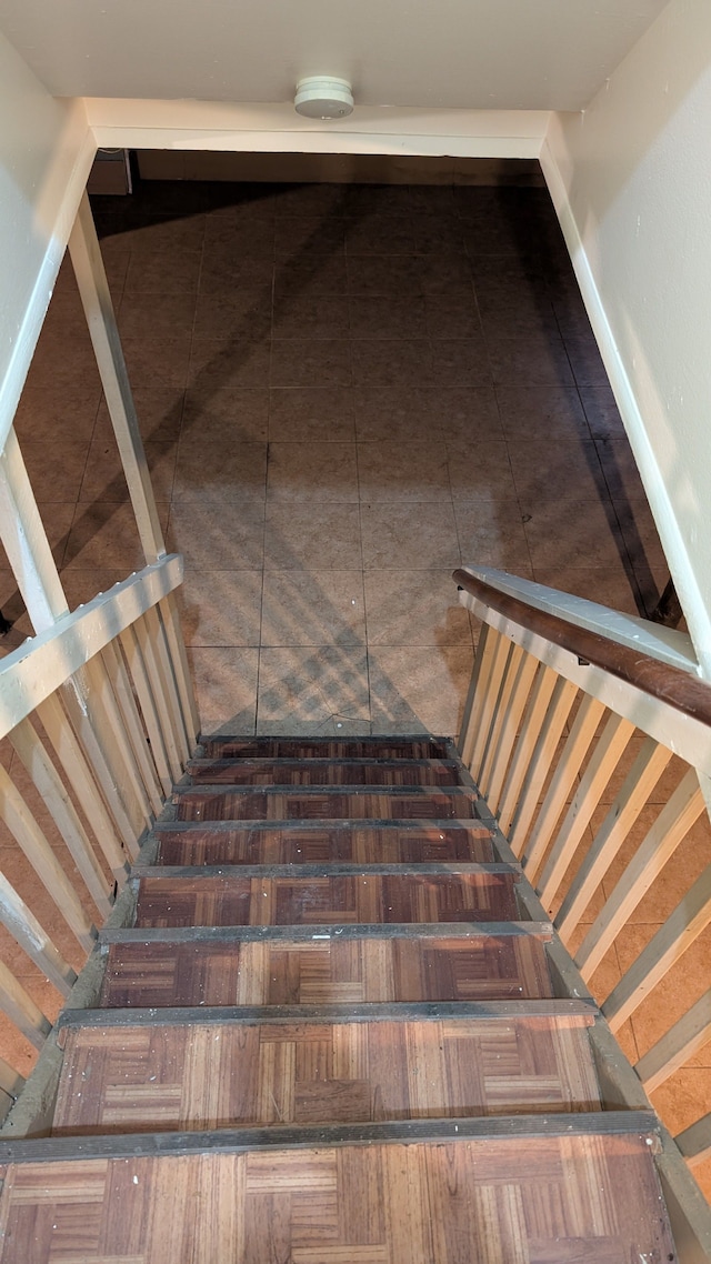 staircase with baseboards and tile patterned floors