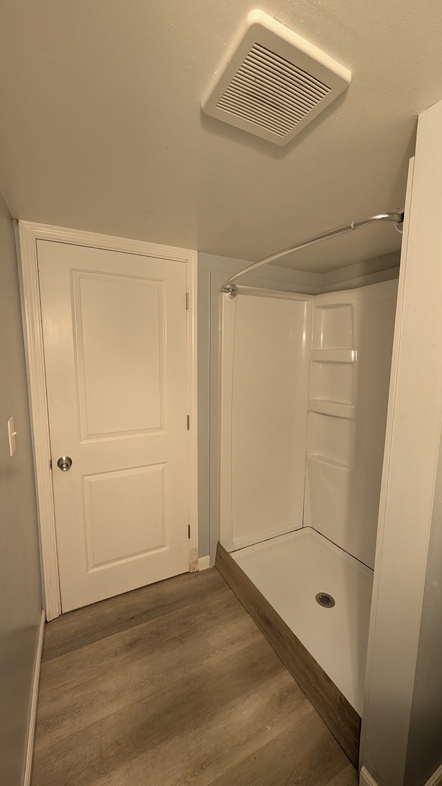 bathroom featuring visible vents, walk in shower, and wood finished floors