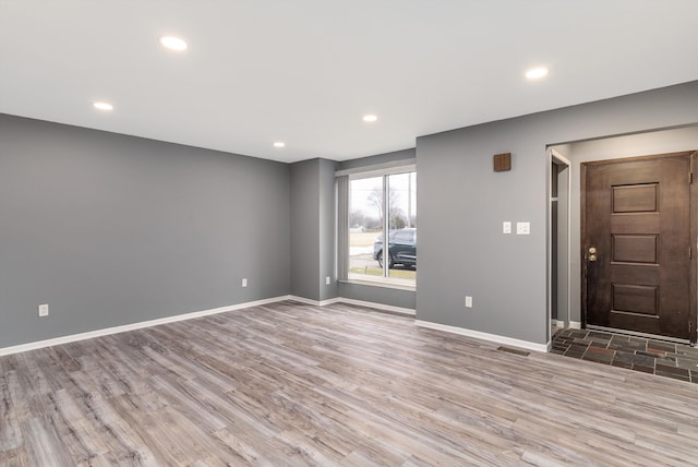 empty room featuring recessed lighting, baseboards, and wood finished floors