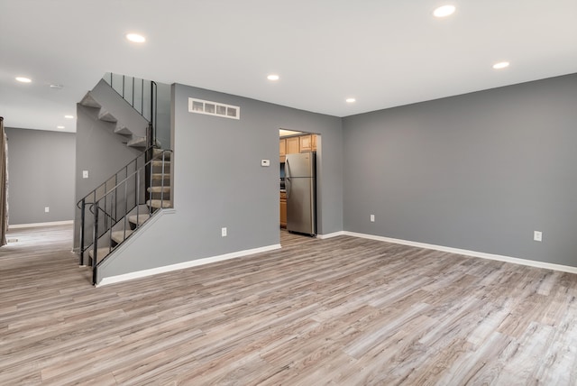empty room with light wood finished floors, baseboards, visible vents, stairs, and recessed lighting